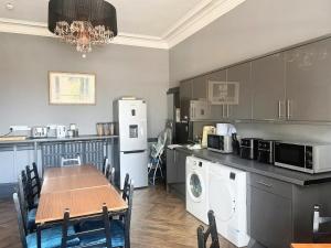 a kitchen with a table and a dining room at The Windsor Hotel and Bar in Kirkcaldy
