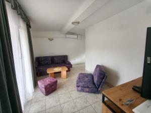 a living room with two chairs and a table at Apartments Šešo A in Pag