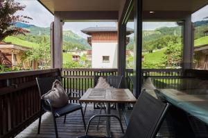 a patio with tables and chairs and a view of the mountains at Apart Marienberg in Lermoos