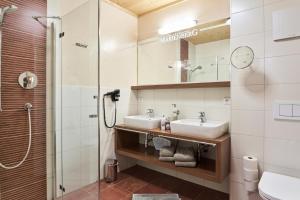 a bathroom with two sinks and a shower at Apart Marienberg in Lermoos +34 photos