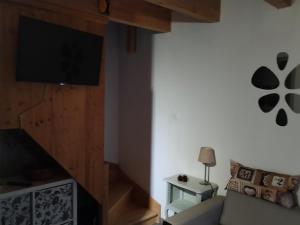 a living room with a couch and a flat screen tv at Le Cigalou - Drôme Provencale in Sainte-Jalle