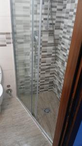 a shower with a glass door in a bathroom at enrica barrani room in Vernazza