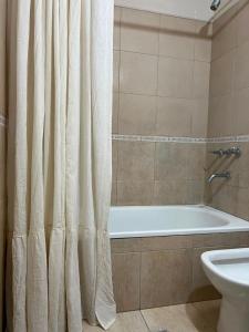 a bathroom with a tub and a shower curtain at Complejo Punto Medio in Santa Rosa +15 photos