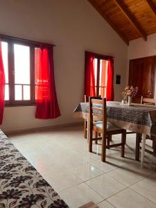 a dining room with red curtains and a table and chairs at Complejo Punto Medio in Santa Rosa
