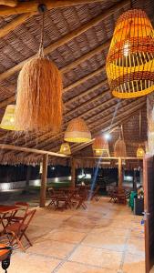 a pavilion with tables and chairs and chandeliers at Bossa Atins in Atins