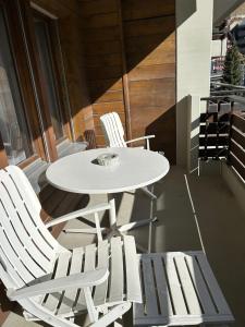 two white chairs and a white table and chairs at Rothornblick in Arosa