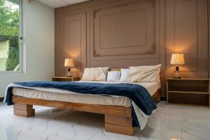 a bedroom with a bed with a blue blanket and two lamps at Brookside Pines in Murree
