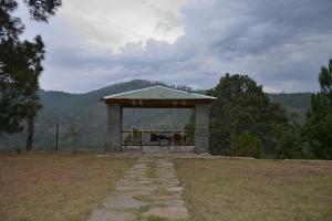 a gazebo in the middle of a field at Brookside Pines in Murree
