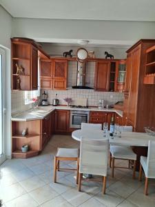 a kitchen with wooden cabinets and a table and chairs at Iliovasilema in Vathý