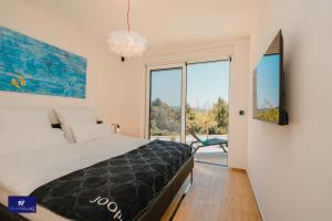 a bedroom with a bed and a large window at Primosten Hills West - Branded Luxury Villa in Primošten +95 photos