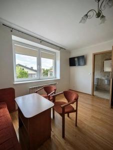 a living room with a table and chairs and a window at Pokoje Gościnne Kalina in Łagów