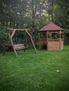 a wooden swing and a gazebo in a yard at Pokoje Gościnne Kalina in Łagów