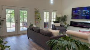 a living room with a couch and a tv at Hale Kululoa in Hilo