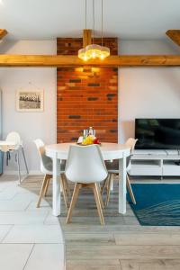 a dining room with a white table and chairs at Apartamenty Centrum - Moonlight in Opole