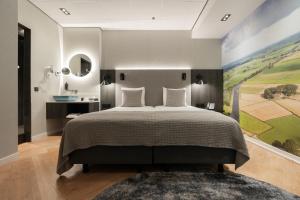 a bedroom with a bed and a painting on the wall at Mercure Hotel Schiphol Terminal in Schiphol