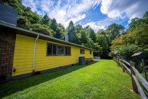 a yellow house with a fence around it at Slay The Dragon Dragon's Lair Cabin in Robbinsville, North Carolina w Creek in Robbinsville