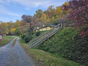 a bridge over a dirt road next to a house at Slay The Dragon Dragon's Lair Cabin in Robbinsville, North Carolina w Creek in Robbinsville