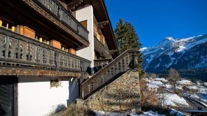 a stairway leading up to a building with a snow covered mountain at Cozy Le Lézard chalet with mountain view fireplace in Les Diablerets