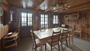 a dining room with a wooden table and chairs at Cozy Le Lézard chalet with mountain view fireplace in Les Diablerets +15 photos