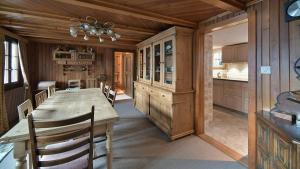 a dining room with a table and a kitchen at Cozy Le Lézard chalet with mountain view fireplace in Les Diablerets