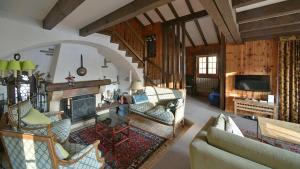 a living room filled with furniture and a fireplace at Cozy Le Lézard chalet with mountain view fireplace in Les Diablerets