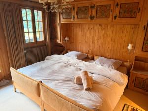 a bedroom with a large bed with a stuffed animal on it at Cozy Le Lézard chalet with mountain view fireplace in Les Diablerets