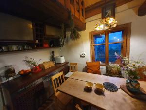 a kitchen and dining room with a table and a window at Ostaya - Mountain Cottage in Obidza