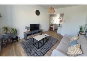 a living room with a couch and a table at Le Petit Logis in Beaurepaire