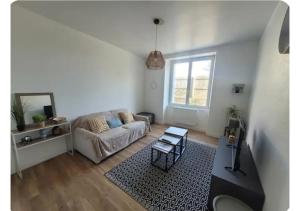 a living room with a couch and a table at Le Petit Logis in Beaurepaire