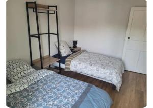 a room with two beds and a shelf at Le Petit Logis in Beaurepaire +1 photo