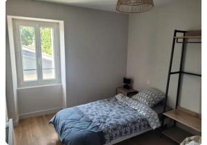 a bedroom with a bed and a window at Le Petit Logis in Beaurepaire