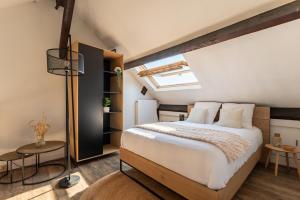 a bedroom with a large bed and a skylight at Duplex de charme dans un Cloître historique Parking privé in Rouen