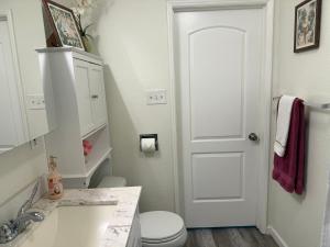 a white bathroom with a toilet and a sink at Hale Kululoa in Hilo +18 photos