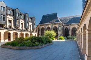a large building with a courtyard in front of it at Duplex de charme dans un Cloître historique Parking privé in Rouen