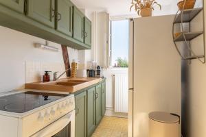 a kitchen with green cabinets and a sink at Duplex de charme dans un Cloître historique Parking privé in Rouen +16 photos