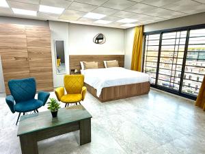 a bedroom with a bed and two chairs and a table at Studio plein centre-ville ! in Fez