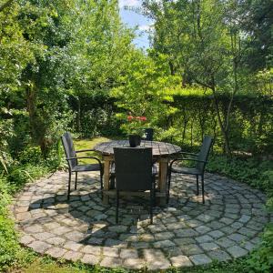 a table and chairs sitting on a stone patio at Kanciapa Sherlocka - Sherlock's Hut in Gubin