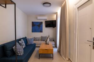a living room with a blue couch and a table at Annasa Suites 2 in Mángana