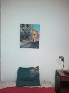 a pillow on a bed with a picture on the wall at Chambre Palais des Papes Avignon in Avignon