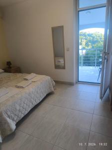 a bedroom with a bed and a sliding glass door at Studio apartmani AHUS in Petrovac na Moru