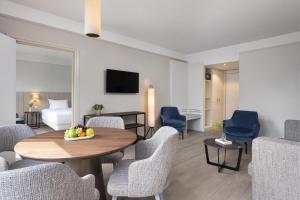 a hotel room with a table and chairs and a bed at NH Bussum Jan Tabak in Bussum