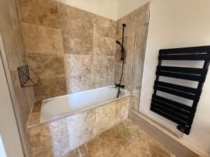 a bathroom with a bath tub in a shower at F4 Cosy Centre Moulins - 3 chambres lits doubles -idéal Famille & Séjour Pro in Moulins +22 photos