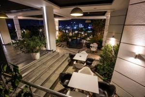 a balcony with tables and chairs and a view of the city at Hotel XXL in Ferizaj