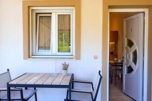a table and chairs in a room with a window at Rousis Studios in Parga