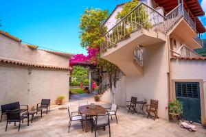 a patio with a table and chairs and a staircase at Rousis Studios in Parga