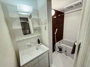 a white bathroom with a sink and a mirror at NUPRIME morishita in Tokyo +41 photos