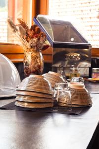 a counter with plates and glasses on top of a table at Le Sire de Joux in Montbenoît +17 photos