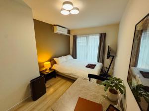 a hotel room with a bed and a desk with a table at NUPRIME morishita in Tokyo