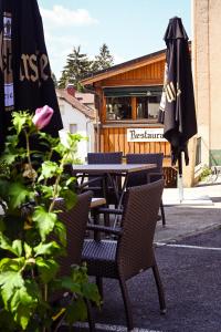 an outdoor table and chairs with an umbrella at Le Sire de Joux in Montbenoît