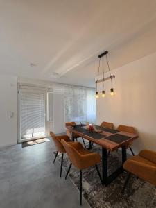 a dining room with a wooden table and chairs at Glory's Apartment in Dußlingen